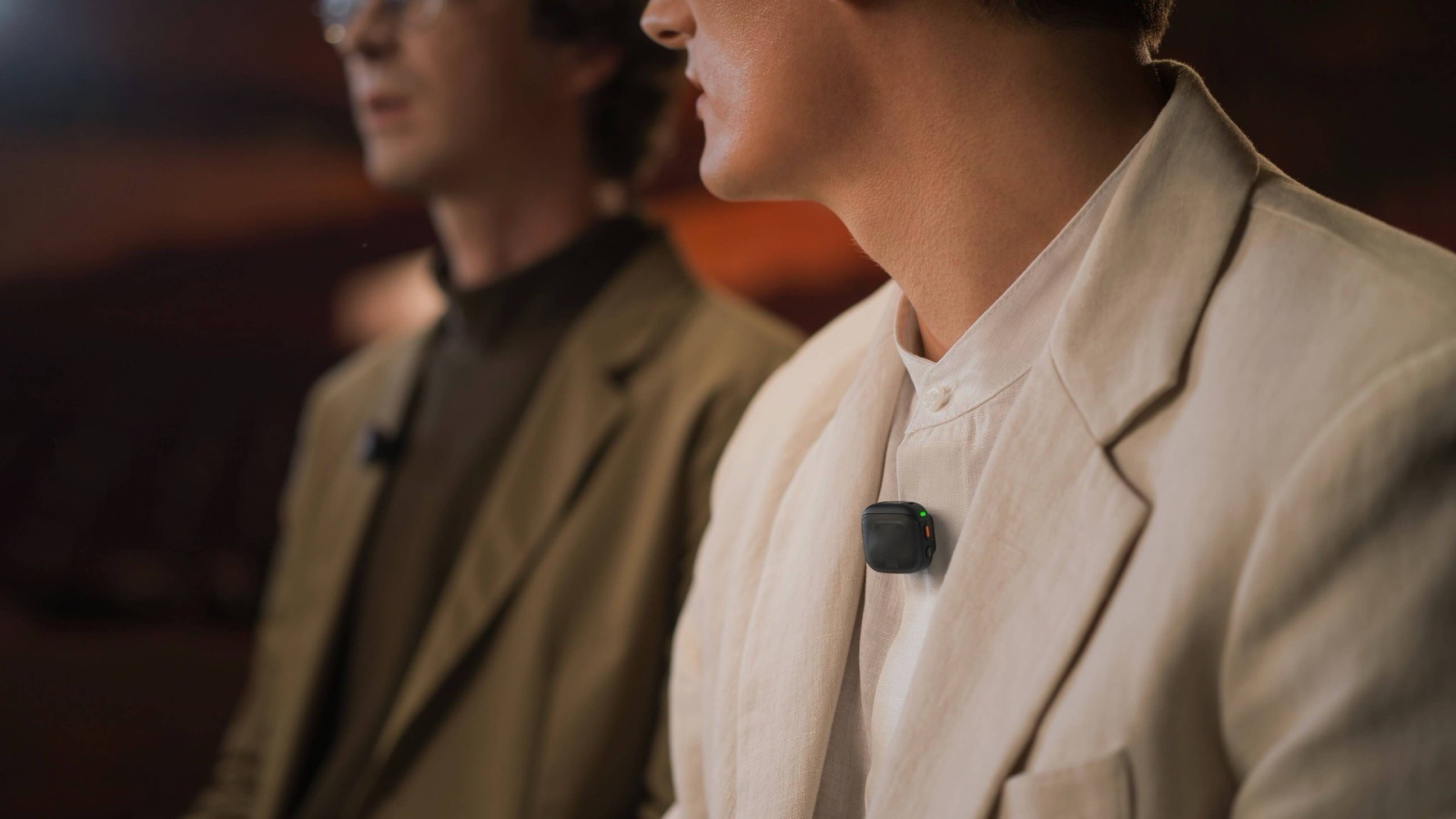 Small wireless transmitter clipped to a speaker's lapel